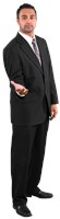 Hussein wearing a suit and holding out right  hand 585